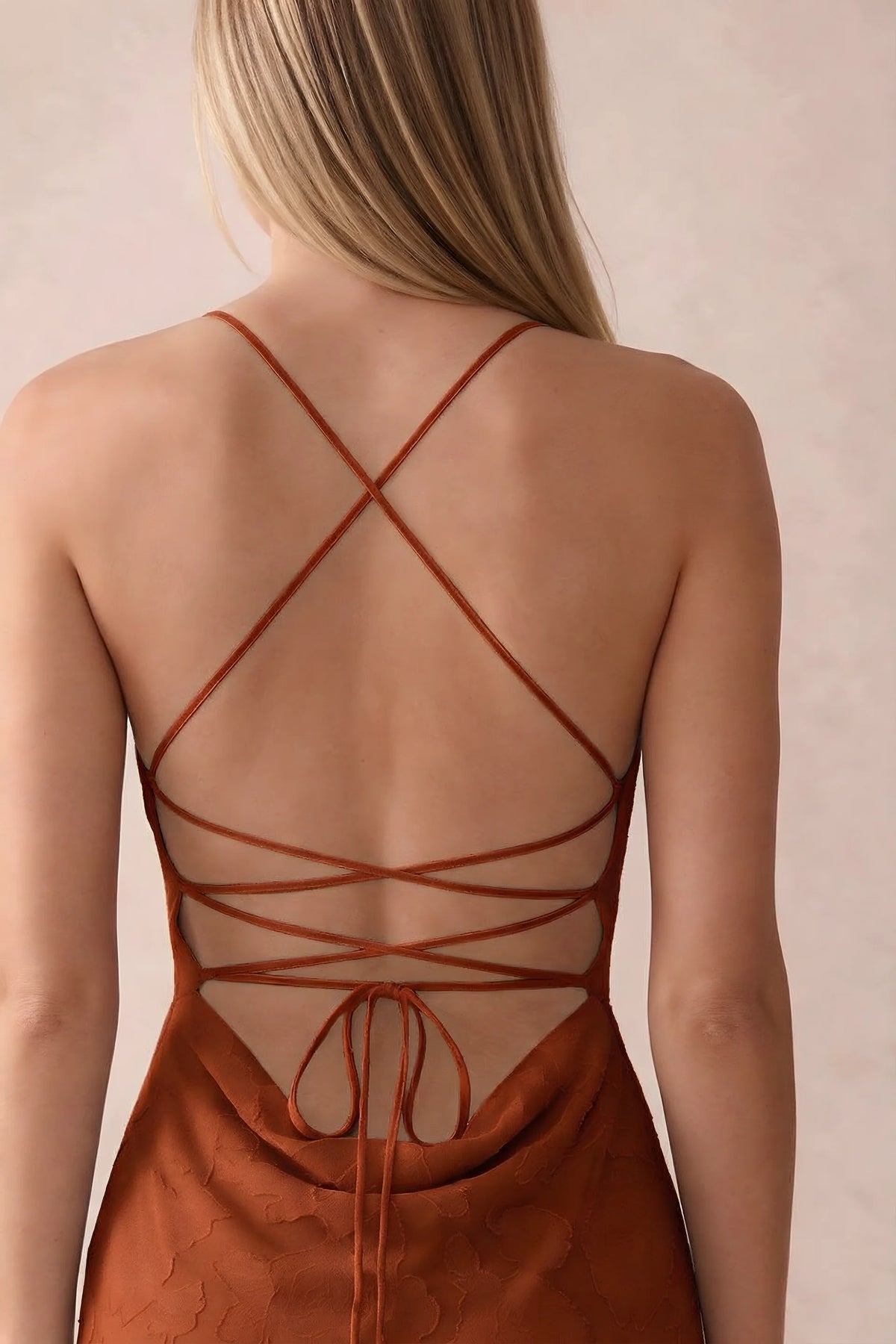 Close-up of Bess paprika open back with crossed straps, tie fastening and low cowl drape