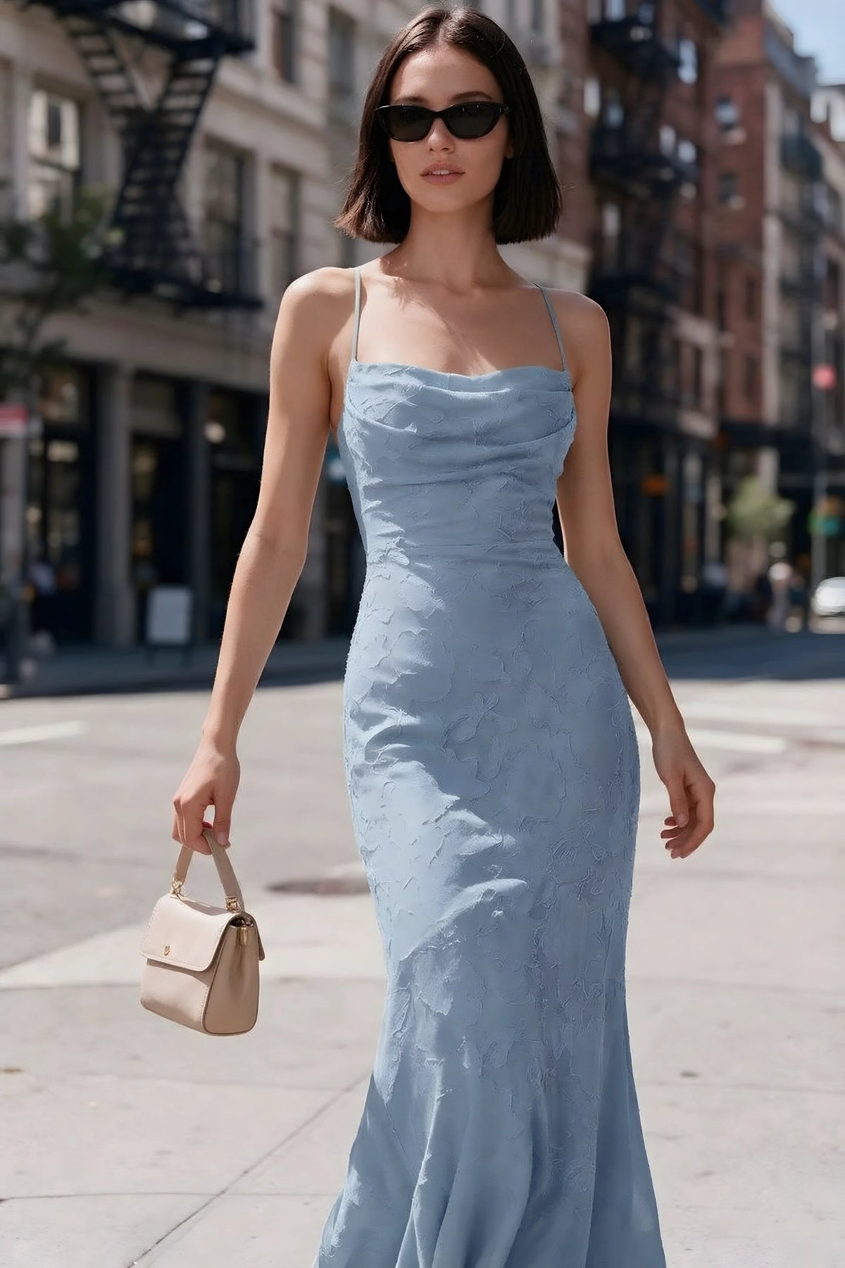 Outdoor front view of Bess powder blue floral burnout dress styled with sunglasses on a city street