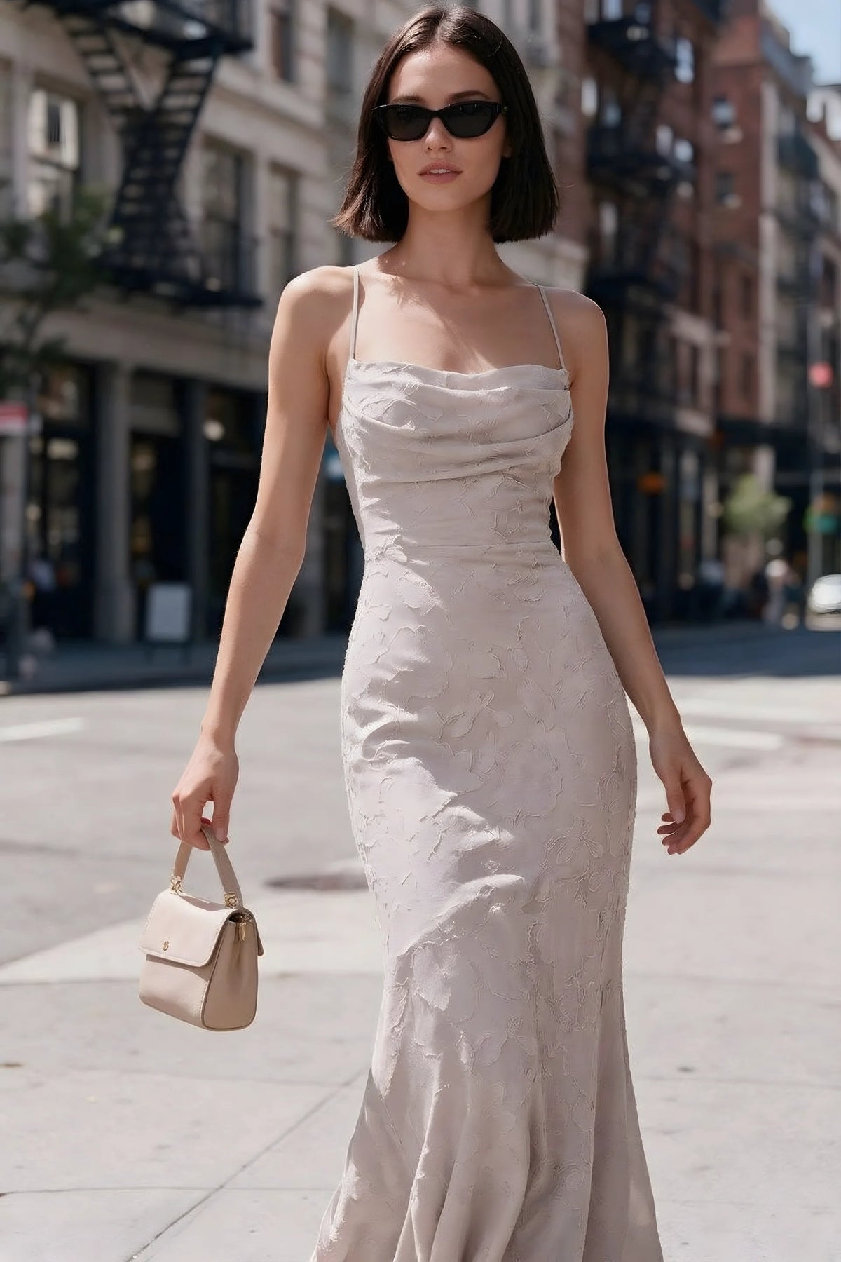 Outdoor front view of Bess powder pink floral burnout dress styled with sunglasses on a city street