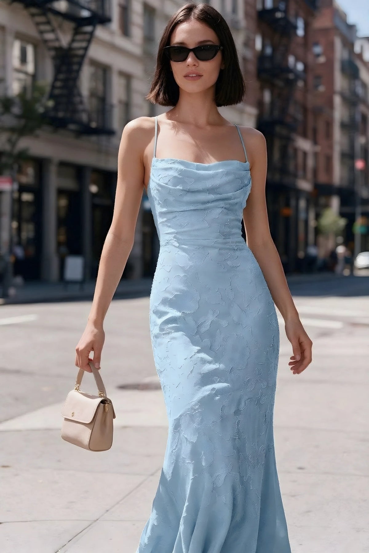 Outdoor front view of Bess sky blue floral burnout dress styled with sunglasses on a city street