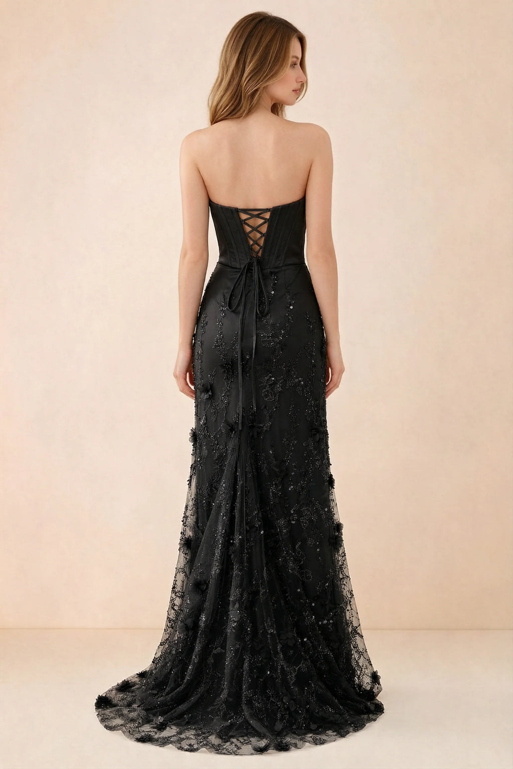 Rear studio view of Beth black dress showing corset back lacing and a trailing floral hem