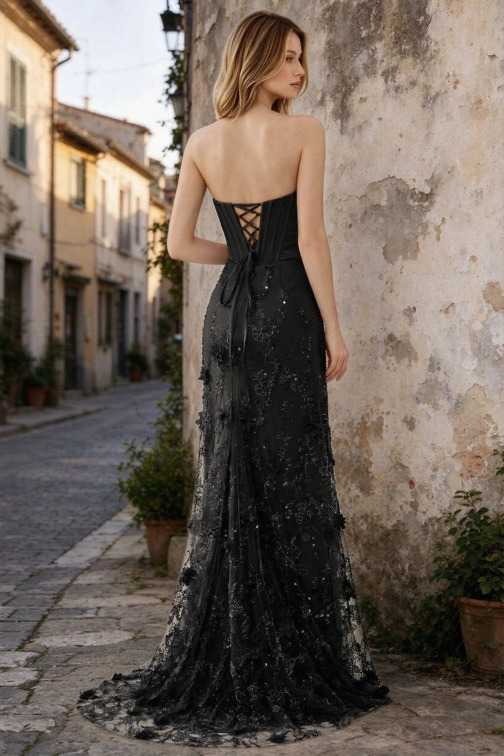 Outdoor rear view of Beth black maxi dress showing back lacing and the long embellished skirt