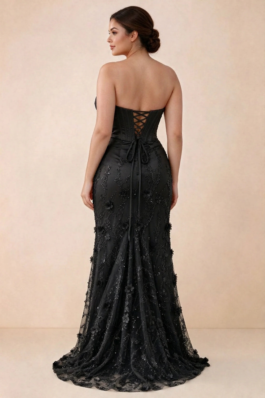 Rear studio view of Beth black corset dress with fine straps, back ties and a trailing hem