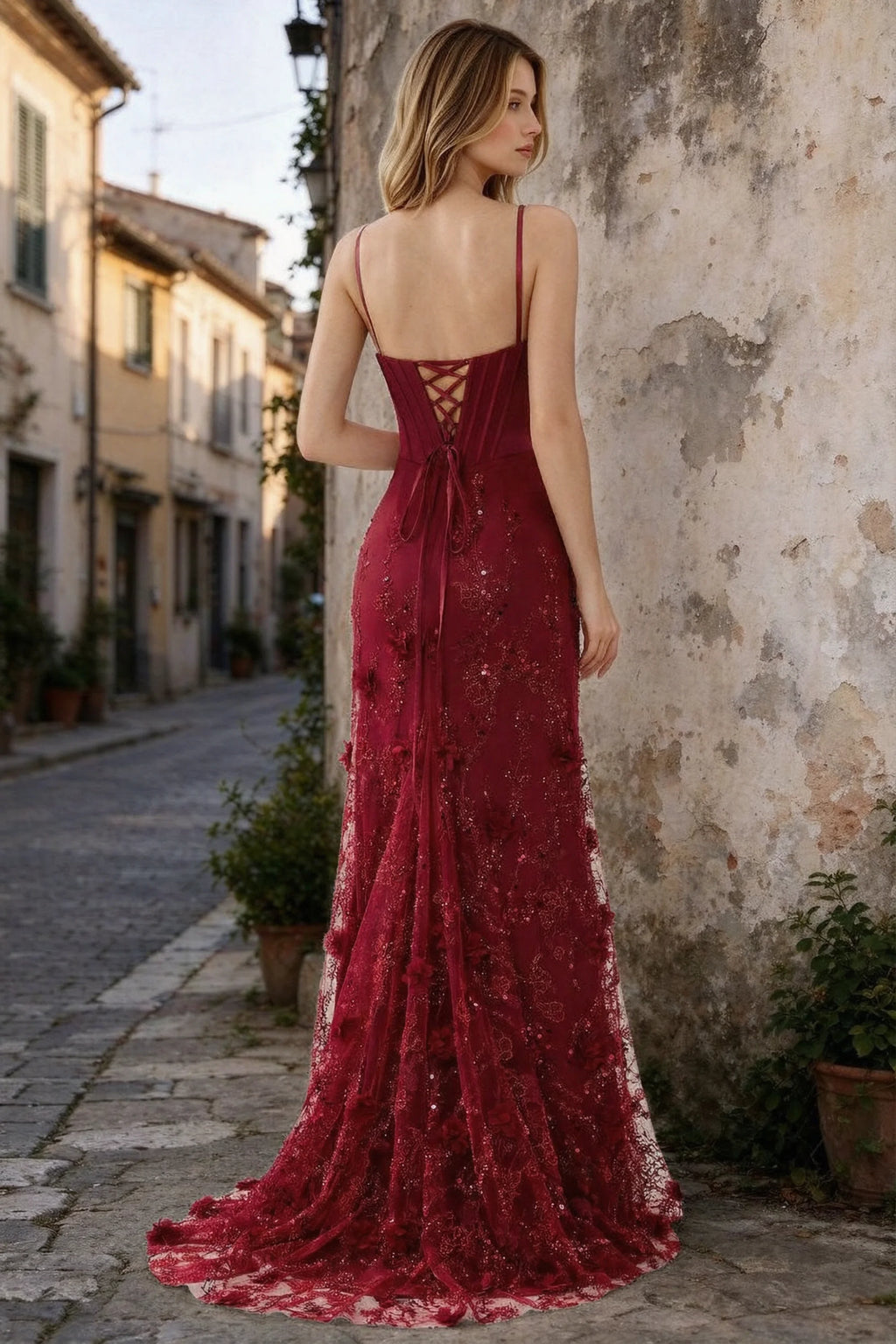 Outdoor rear view of Beth burgundy maxi dress showing back lacing and the long embellished skirt
