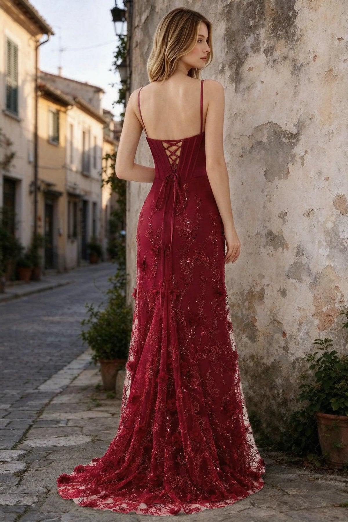 Outdoor rear view of Beth burgundy maxi dress showing back lacing and the long embellished skirt