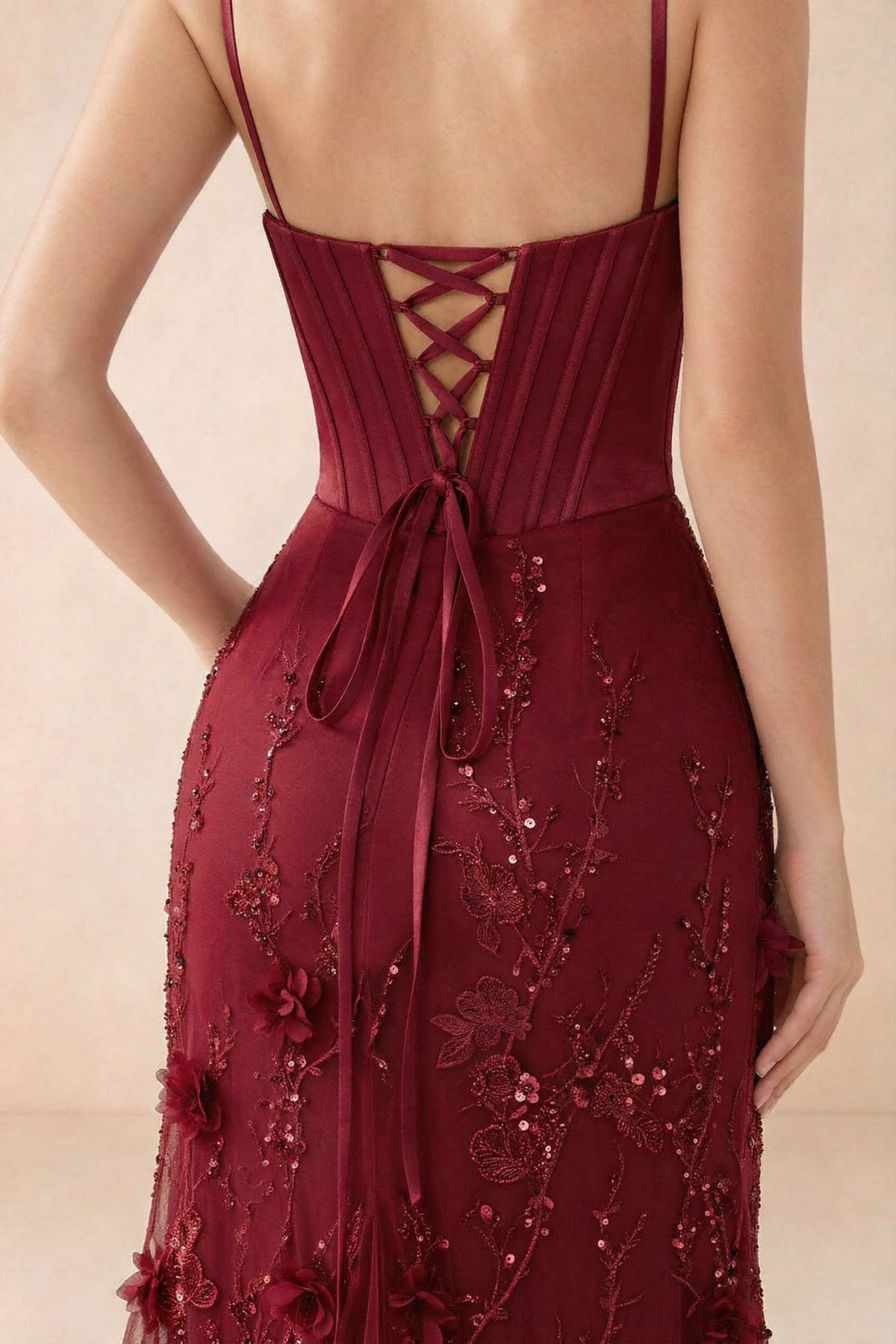 Close-up of Beth burgundy lace-up corset back, fine straps and embellished skirt