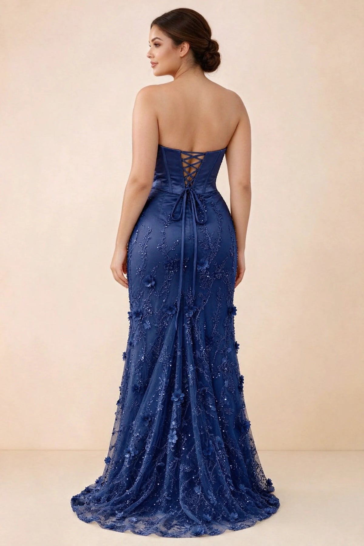Rear studio view of Beth navy corset dress with fine straps, back ties and a trailing hem