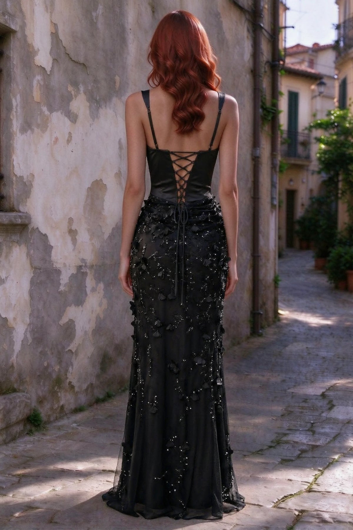 Outdoor rear view of Betsy black maxi dress showing the lace-up bodice and long floral skirt