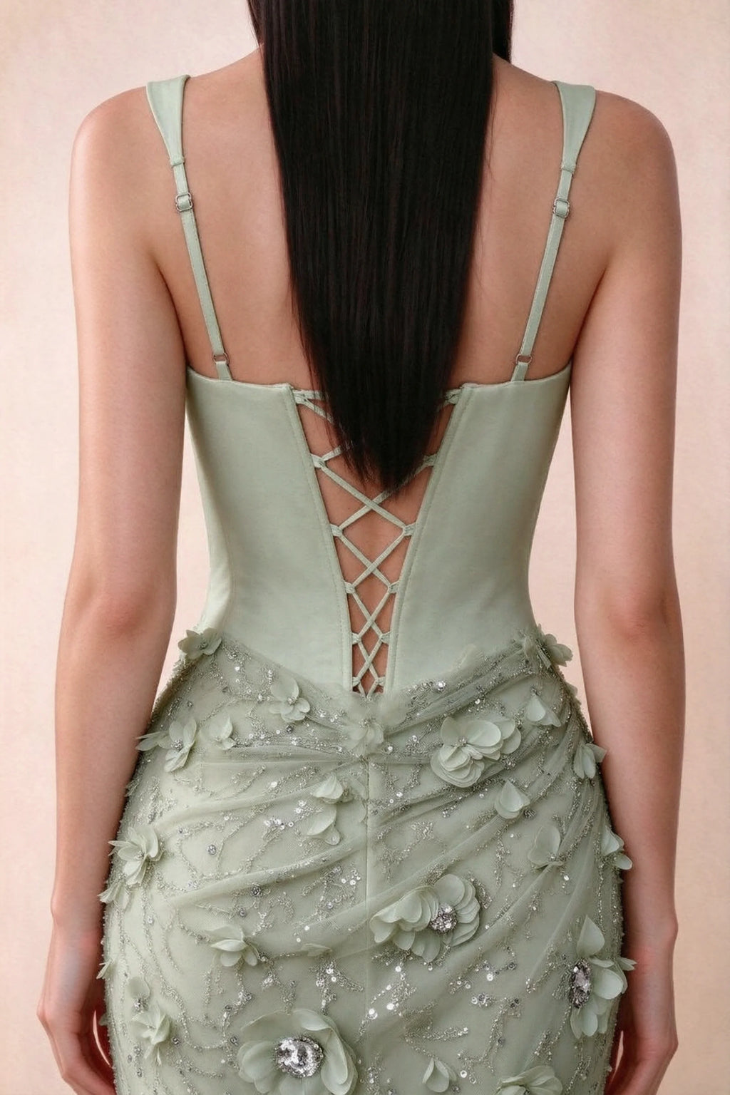 Close-up of Betsy sage green adjustable strap sliders and crossed back lacing above the beaded skirt