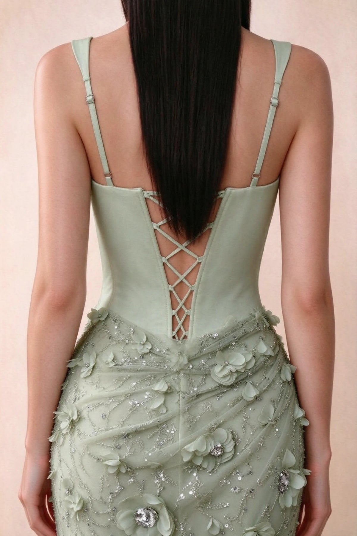 Close-up of Betsy sage green adjustable strap sliders and crossed back lacing above the beaded skirt