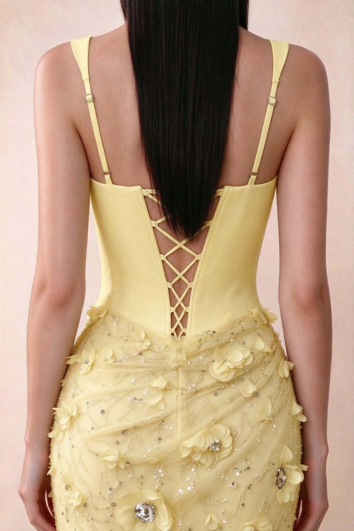 Close-up of Betsy yellow adjustable strap sliders and crossed back lacing above the beaded skirt