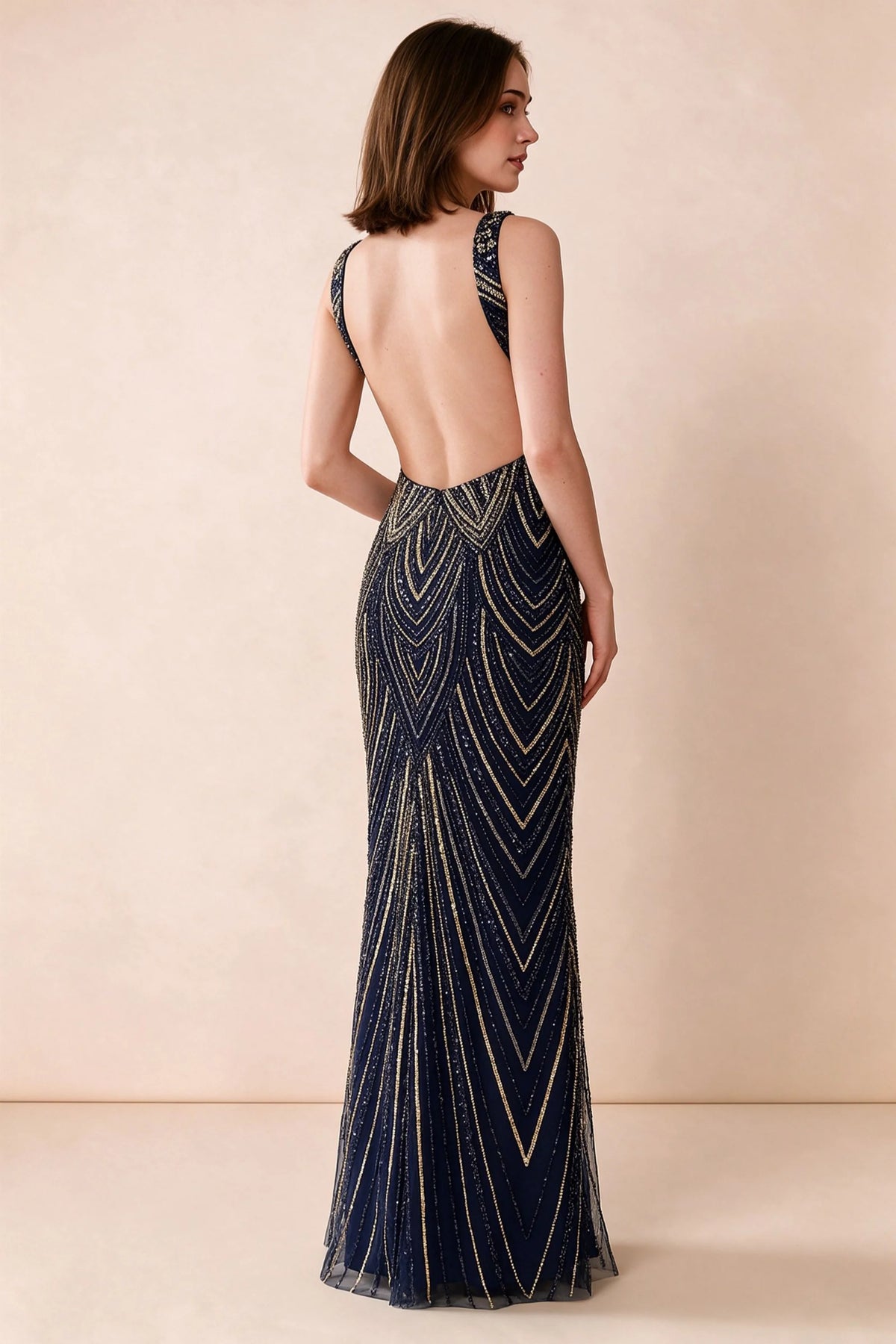Rear studio view of Betty navy and gold dress showing wide shoulder straps and a low scooped open back