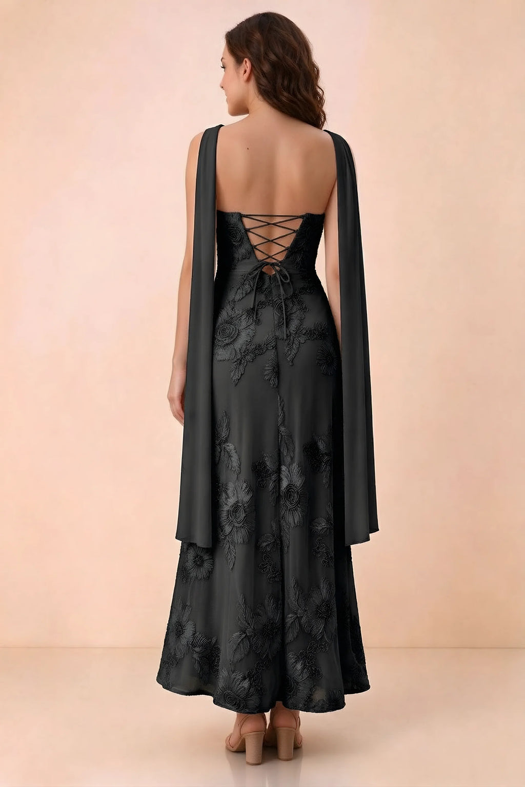 Rear studio view of Carey black dress showing crossed back lacing and scarf ends draped over the shoulders
