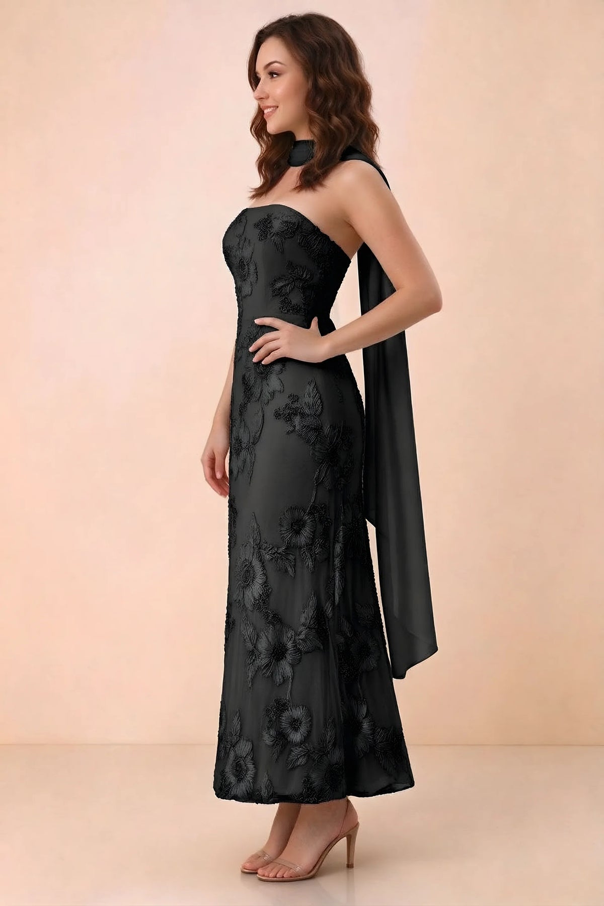 Three-quarter studio view of Carey black strapless dress showing the fitted waist and floral appliques