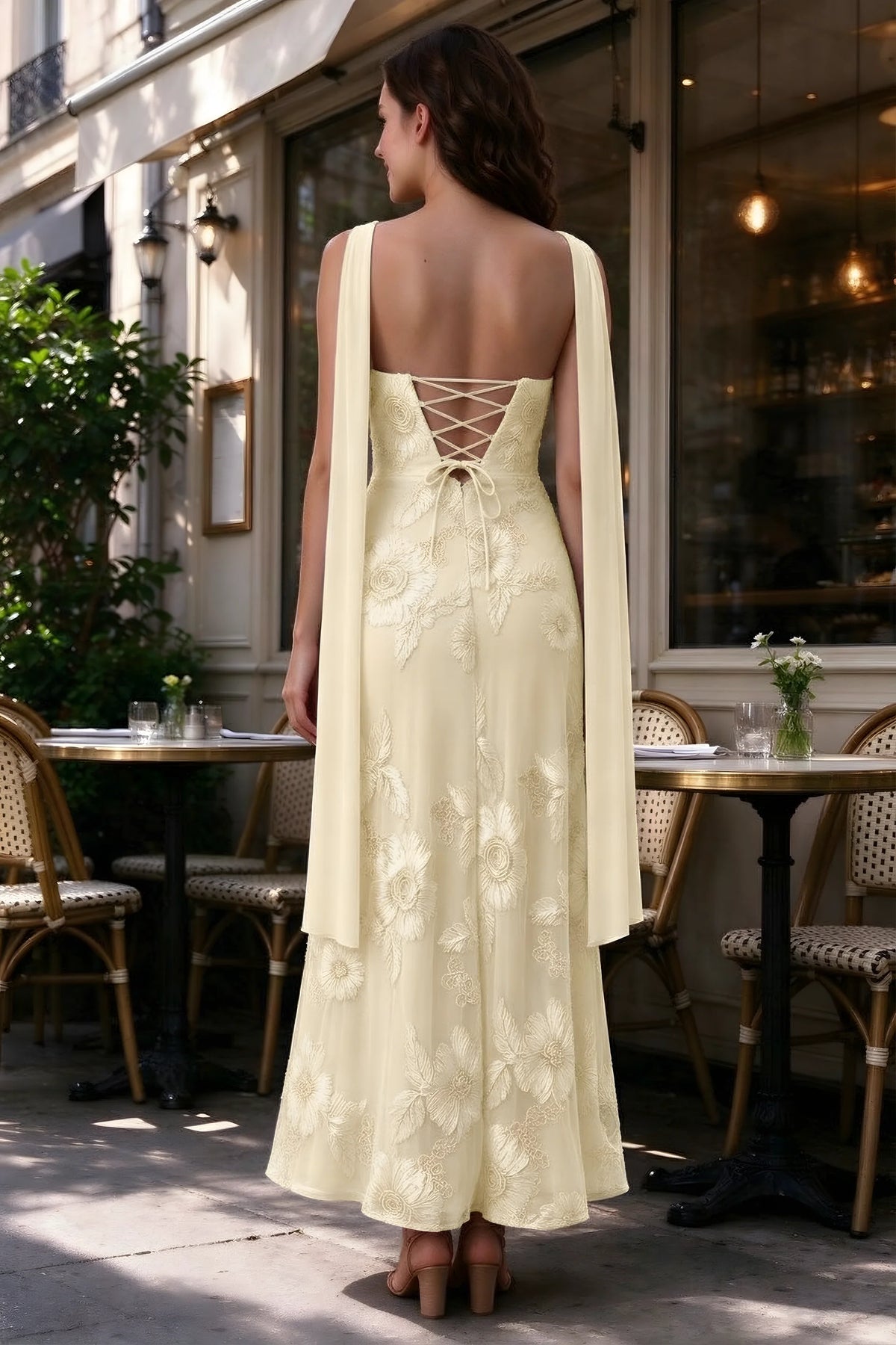 Outdoor rear view of Carey lemon dress showing the lace-up back and long scarf ends