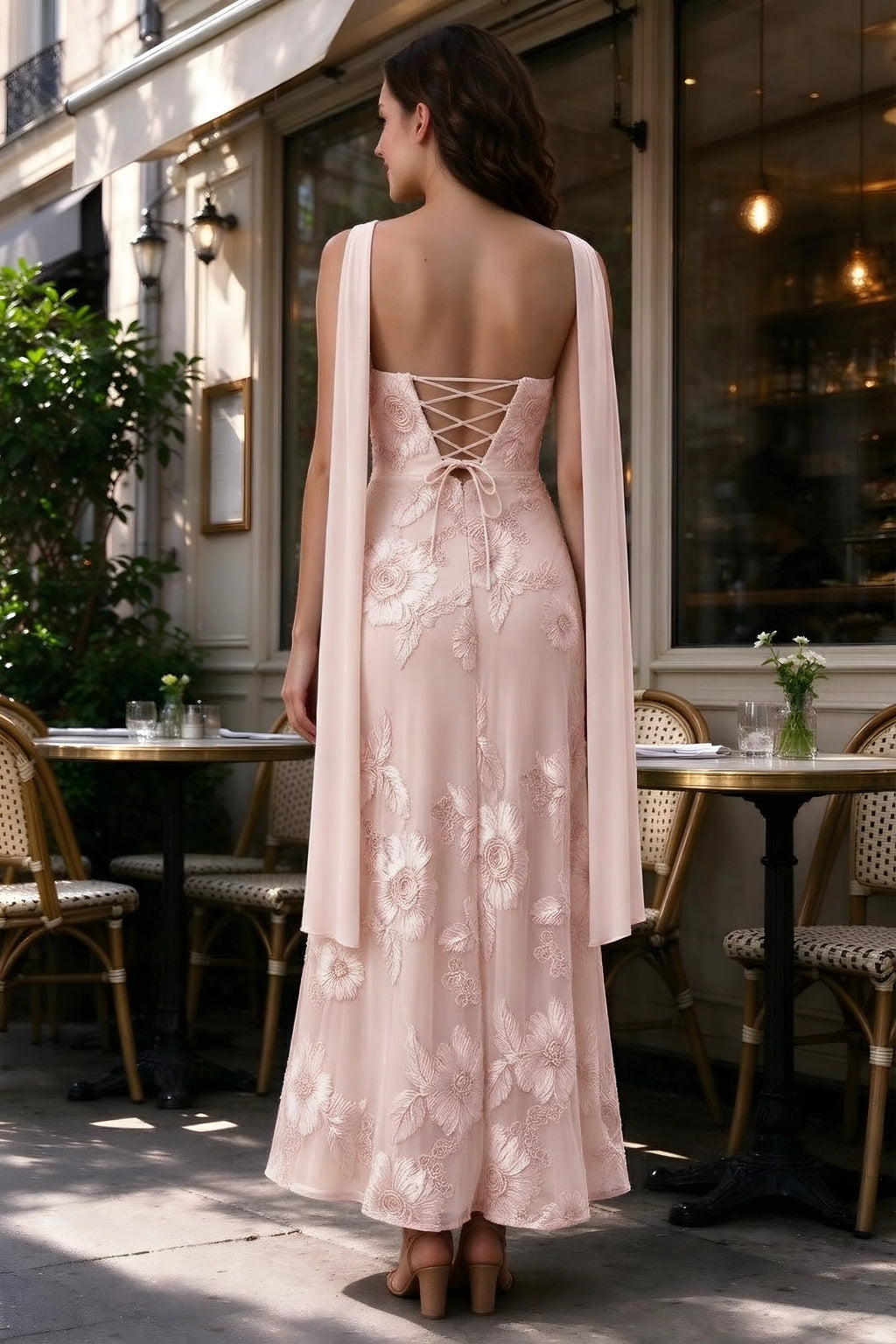 Outdoor rear view of Carey light pink dress showing the lace-up back and long scarf ends