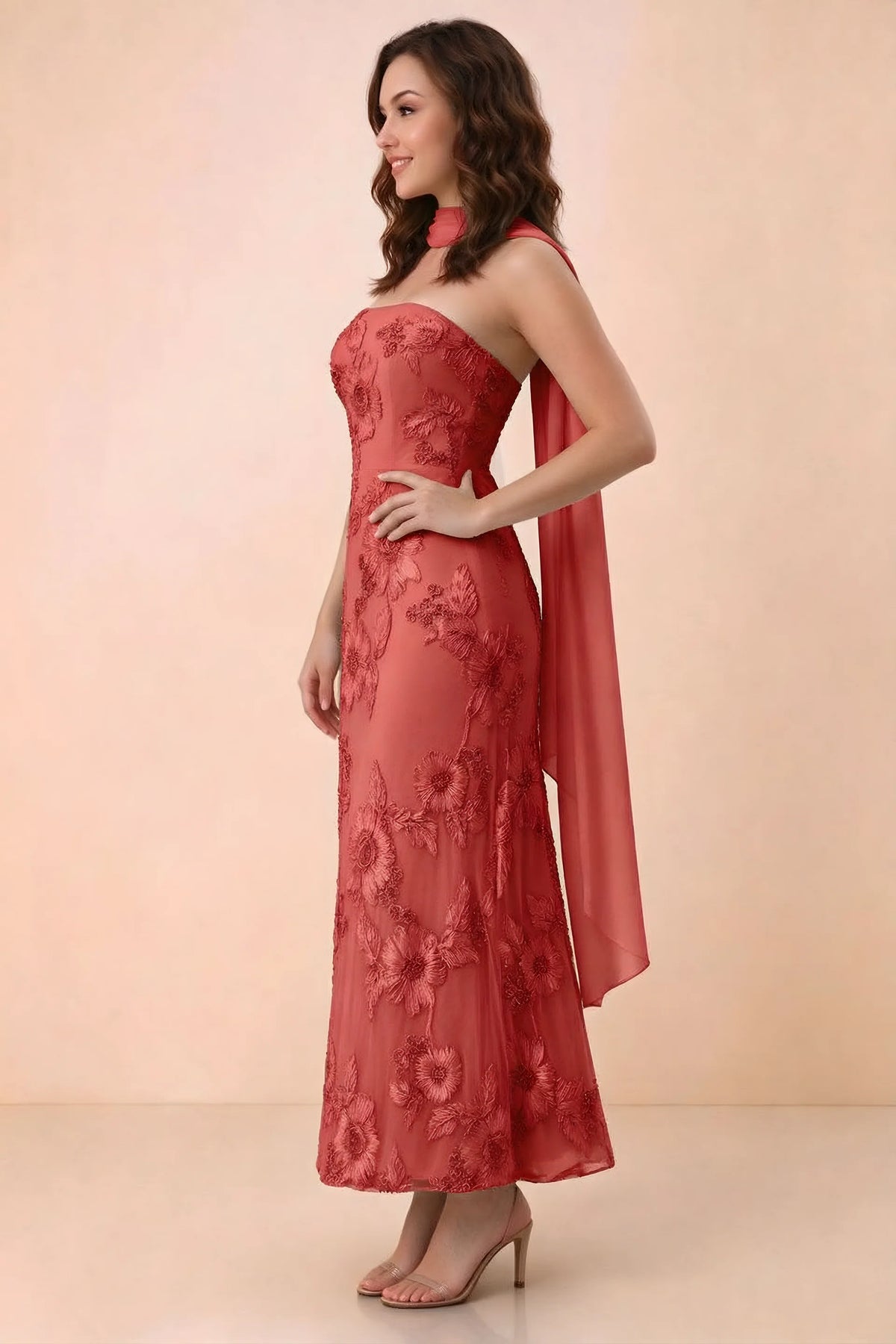 Three-quarter studio view of Carey red strapless dress showing the fitted waist and floral appliques