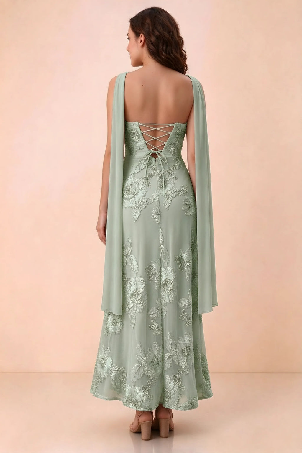 Rear studio view of Carey sage green dress showing crossed back lacing and scarf ends draped over the shoulders