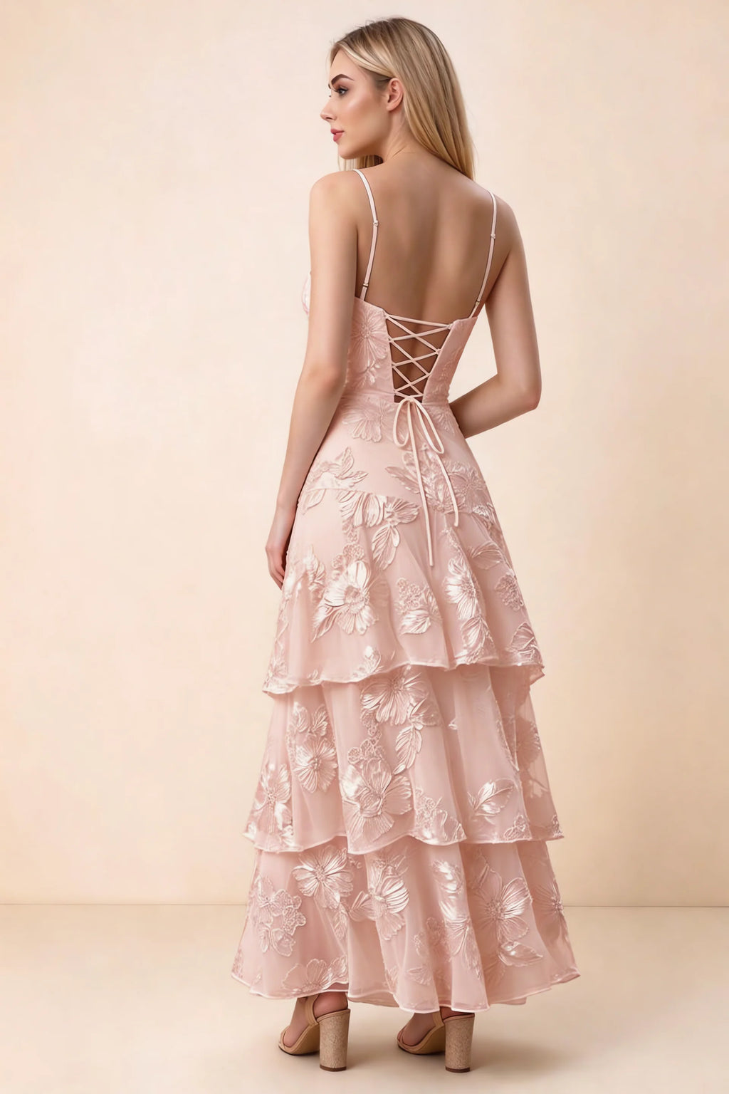 Rear studio view of Bonnie light pink dress showing adjustable straps, back lacing and tiered ruffles