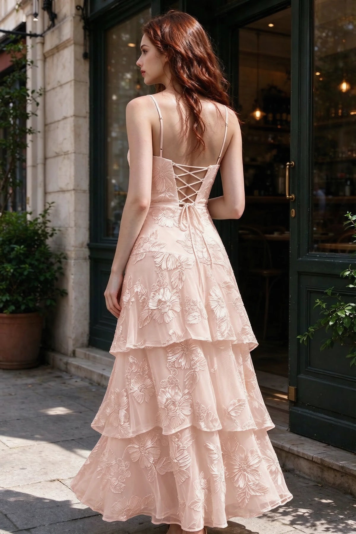 Outdoor rear view of Bonnie light pink dress showing the lace-up back and layered skirt
