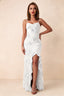 Front studio view of Brianna white floral maxi dress with thin straps and a high ruffle-edged opening