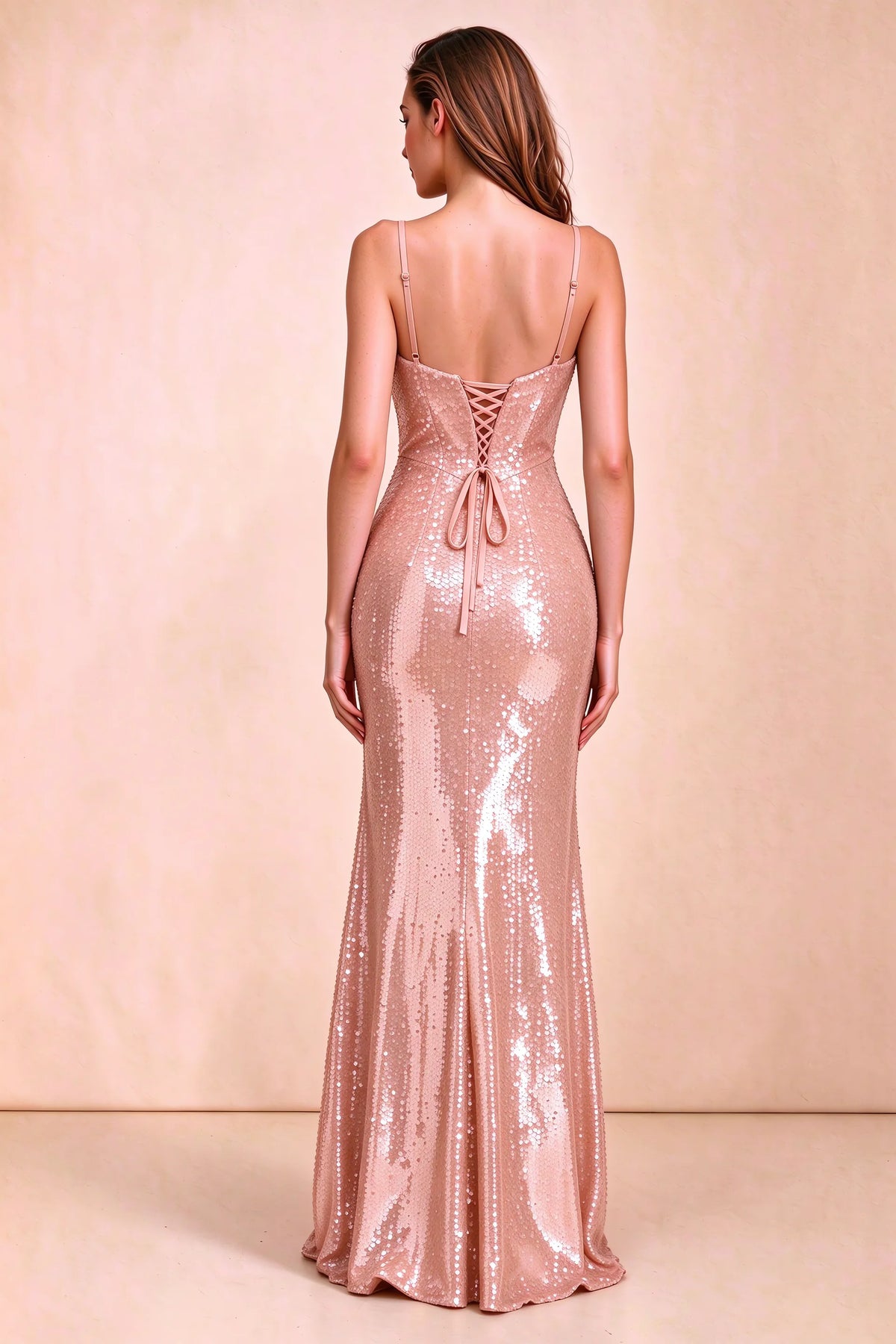 Rear three-quarter studio view of Callie rose gold dress showing the centre-back lacing and mermaid skirt