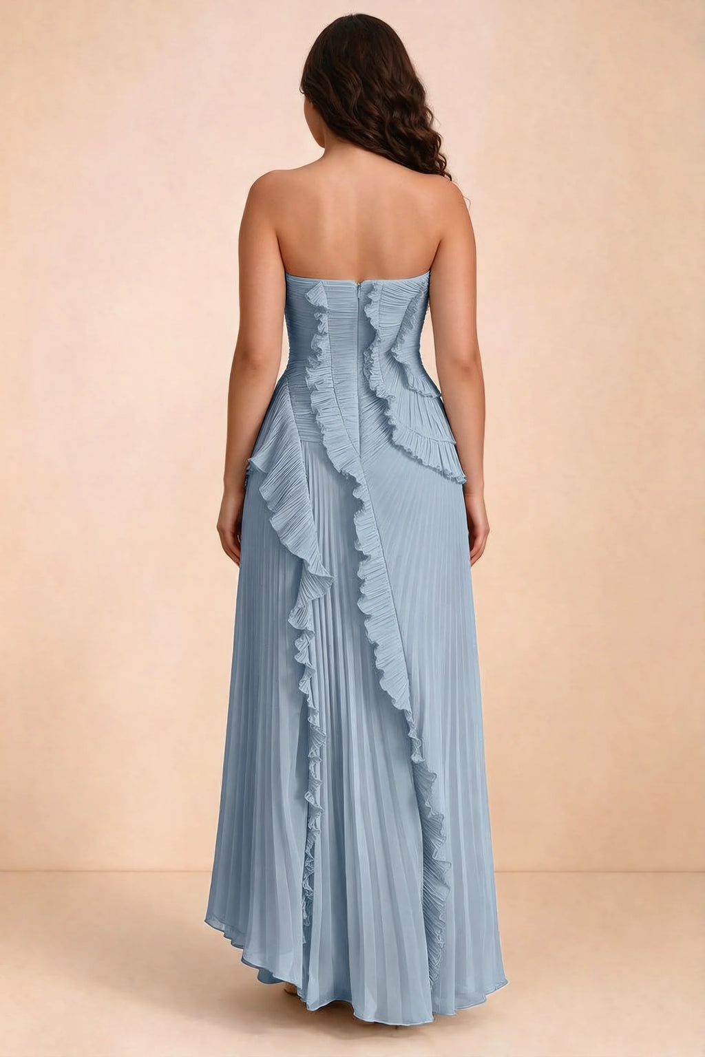Rear studio view of Camilla dusty blue dress on a second model, showing the ruffled back and pleated skirt