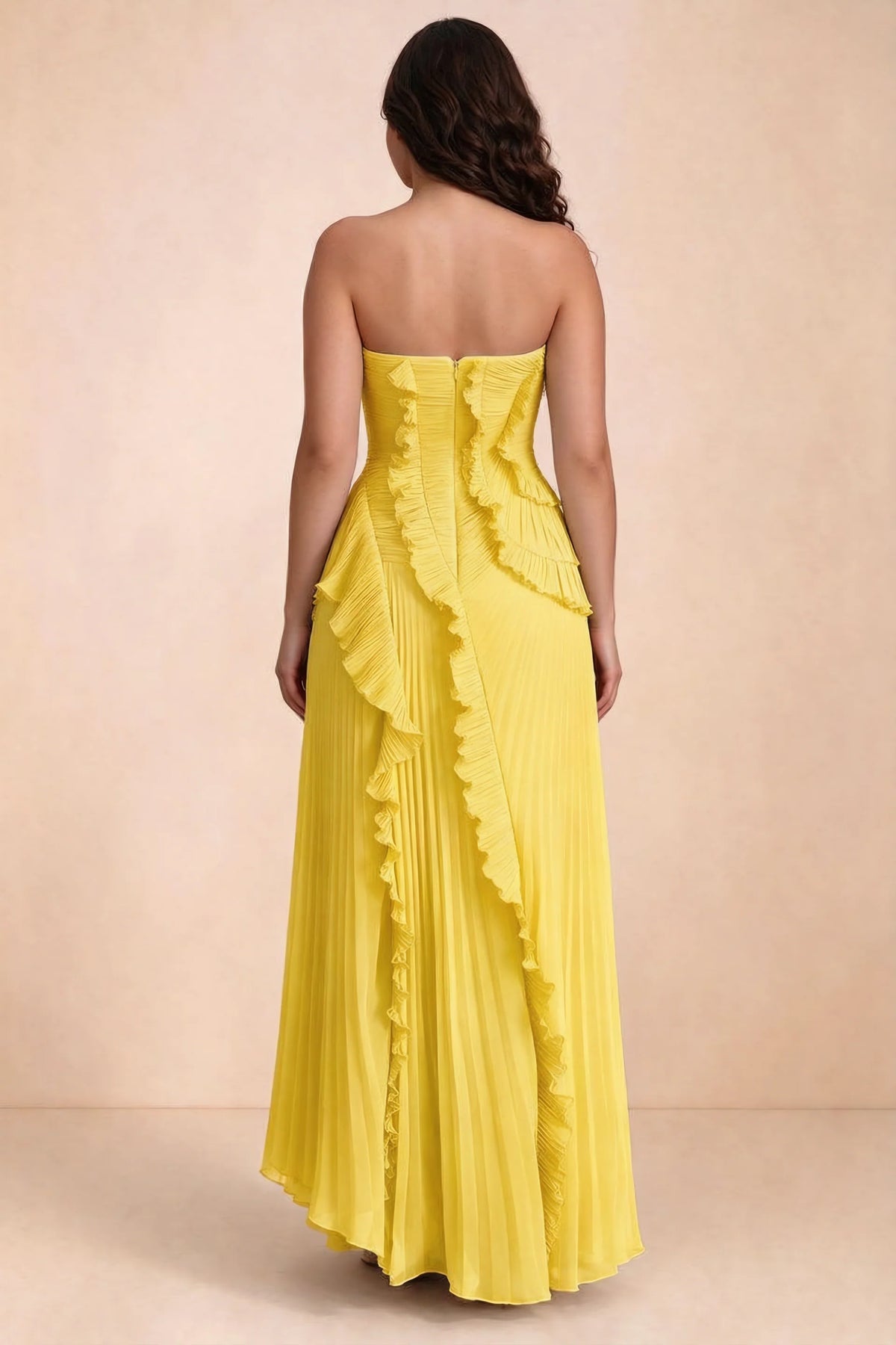 Rear studio view of Camilla yellow dress on a second model, showing the ruffled back and pleated skirt