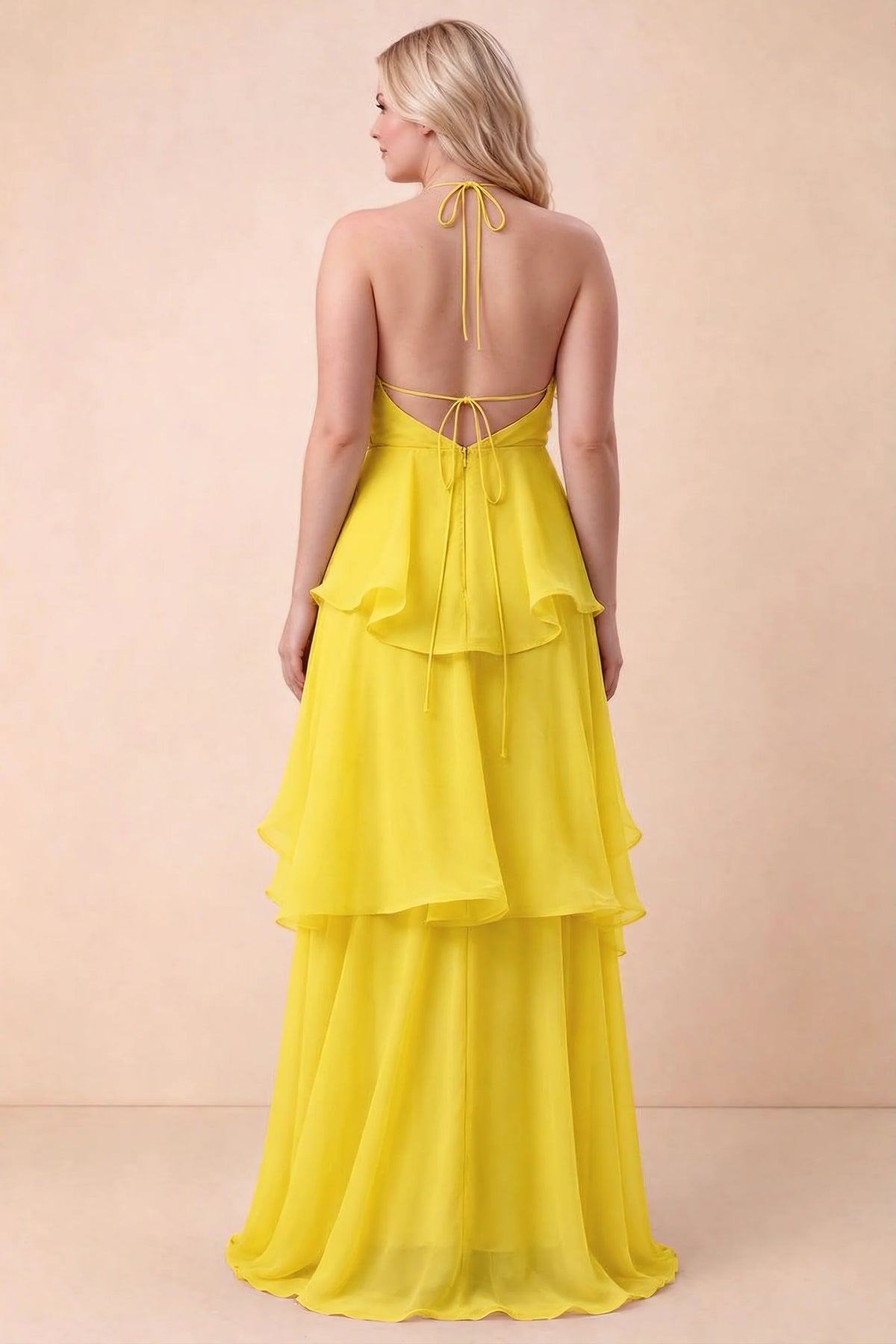 Rear studio view of Candace yellow dress on a second model, showing the open back and long hem