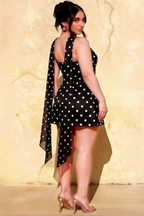 Plus size fashion model in LVLVS Candice black polka dot crepe dress side view showing asymmetrical hemline and flowy chiffon scarf detail