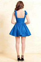 Back view of LVLVS Cassandra royal blue mini skater dress showing open back and bow details for formal event