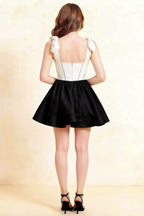 Back view of LVLVS Cassandra white and black bow straps mini skater dress with square neckline for semi-formal event