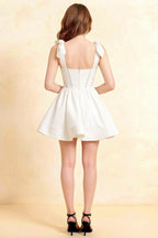 Back view of LVLVS Cassandra white mini skater dress with bow straps and open back design, ideal for prom and formal occasions, made from comfortable stretch crepe material