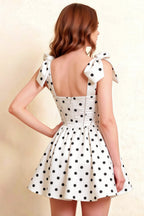 Detailed back view of LVLVS Cassandra white polka dot dress highlighting bow ties and corset style closure for classy occasions