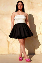 Plus size model wearing LVLVS Catherine white and black bandeau ruffle mini dress in an outdoor urban setting, stylish choice for club nights and going out.