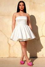 Plus size model in white strapless Catherine mini dress styled for graduation and elegant garden parties.
