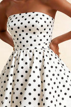 Detailed close-up of the LVLVS Catherine white polka dot bandeau ruffle mini dress emphasizing the textured bonded crepe fabric and gathered waist detail for office work.