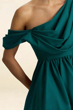 Close-up macro shot of LVLVS Cecilia dress fabric and construction, focusing on the luxurious crepe texture and intricate one shoulder knot detail for wedding guest attire.