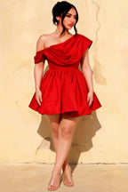 Plus size model wearing LVLVS Red Cecilia Dress, figure-flattering one shoulder draped style, crepe mini skater dress designed for curvy women attending parties and formal dinners.