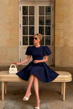 Customer Wearing LVLVS Celia Navy Blue Midi Dress Casual Elegant Look Sitting on Bench Sunglasses White Handbag Resort Wear Style