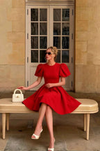 Street style photo of LVLVS Celia red crew neck dress worn by customer sitting on bench, classy brunch or day party outfit, chic short formal dress with white heels