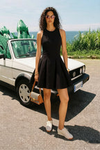Real customer wearing Cheryl black sleeveless skater mini dress, casual chic style for daytime events, paired with white sneakers
