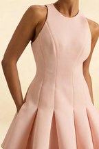 Textile detail of the Cheryl blush crepe dress, emphasizing the smooth fabric texture, round neckline, and precise seam construction.