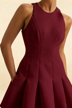 Detailed fabric texture of burgundy round neck Cheryl dress, focus on pleated waist seam, high quality crepe material.