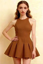 Close-up front brown Cheryl dress coffee crepe round neck sleeveless skater mini dress, model hand on hip showcasing tailored bodice