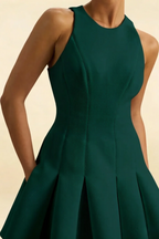 Curvy model showcasing the Cheryl emerald dress, emphasizing the comfortable stretch crepe fabric and the elegant high-low hem of the skater skirt.