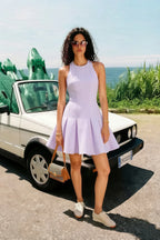 Real customer wearing lavender Cheryl crepe dress, round neck sleeveless skater mini dress, casual chic style with sneakers & wicker bag, outdoor summer event, travel, brunch outfit.