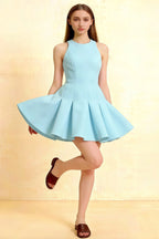 Light blue Cheryl crepe dress with round neck and pleated skater skirt, model posing in studio for homecoming or semi-formal event.