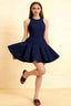 Young woman twirling in a navy blue Cheryl skater dress, showcasing its fit-and-flare silhouette and round neckline. Perfect for semi-formal parties, homecoming, or cocktail events.