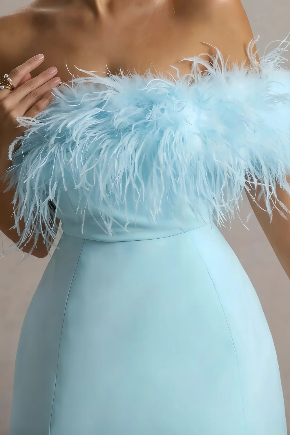 Close-up of Chloe light blue dress feather trim, highlighting soft texture and craftsmanship of the off-shoulder design.